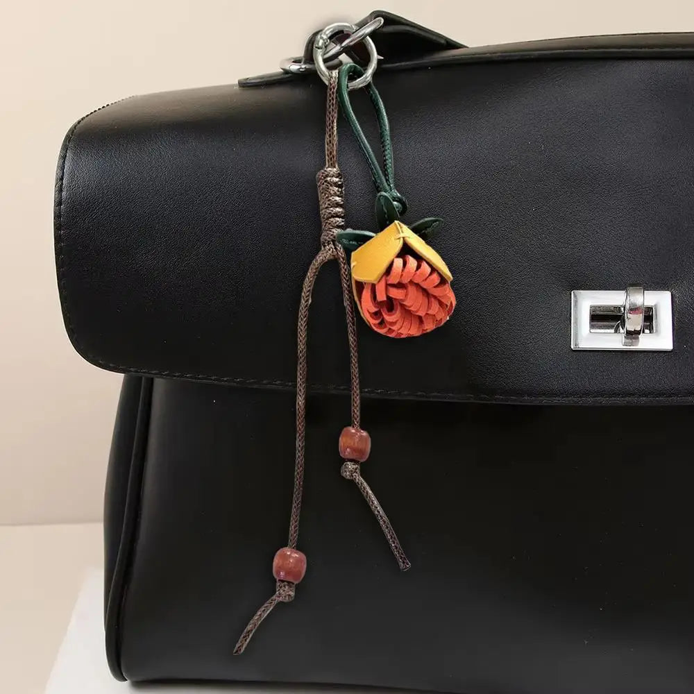Breloque de sac à main avec pompon fleuri pour femme, porte-clés haut de gamme en cuir PU, pendentif en corde tressée avec pomme de pin et fleur.