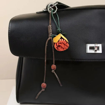 Breloque de sac à main avec pompon fleuri pour femme, porte-clés haut de gamme en cuir PU, pendentif en corde tressée avec pomme de pin et fleur.