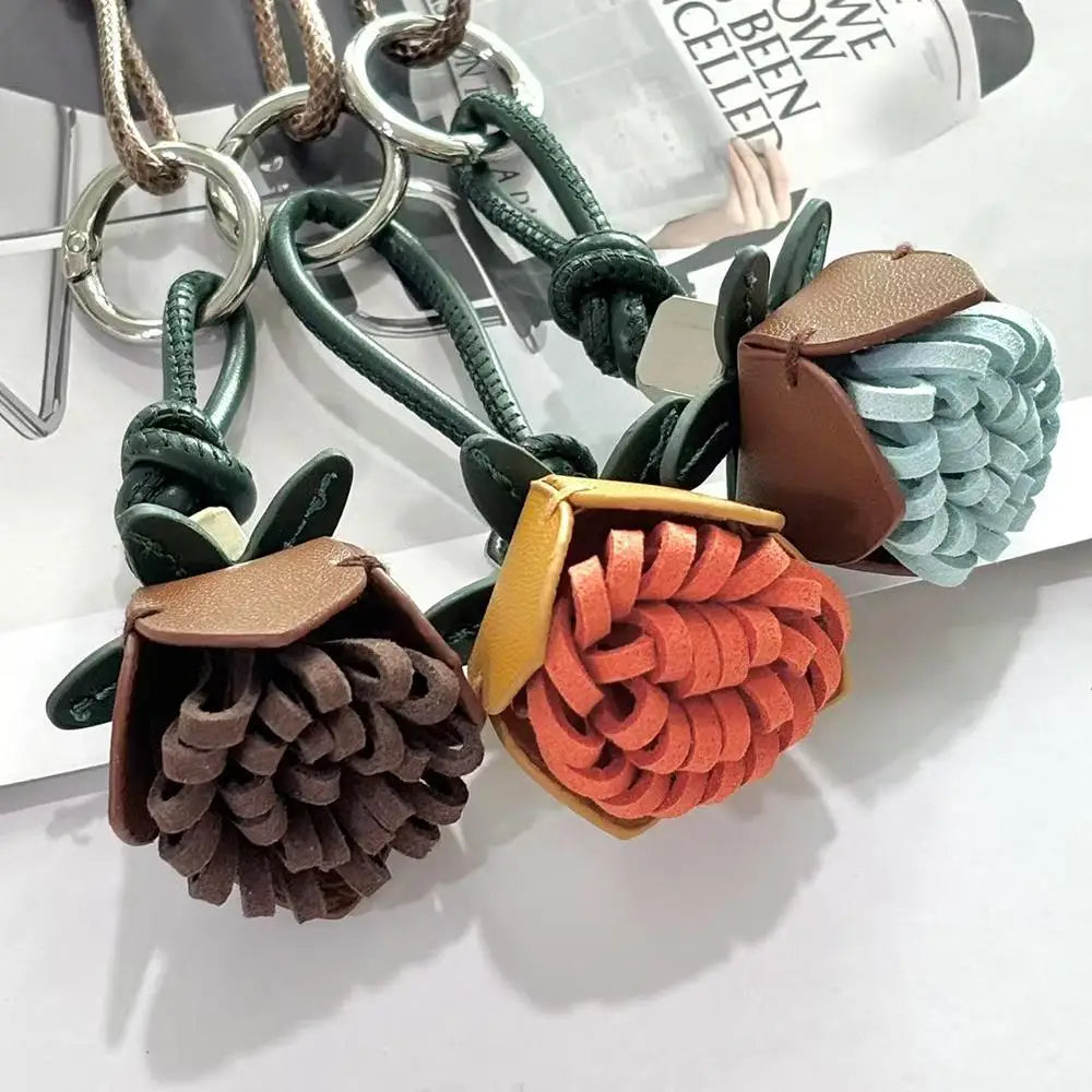 Breloque de sac à main avec pompon fleuri pour femme, porte-clés haut de gamme en cuir PU, pendentif en corde tressée avec pomme de pin et fleur.
