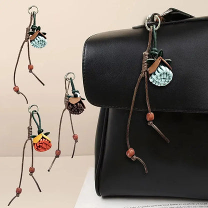 Breloque de sac à main avec pompon fleuri pour femme, porte-clés haut de gamme en cuir PU, pendentif en corde tressée avec pomme de pin et fleur.