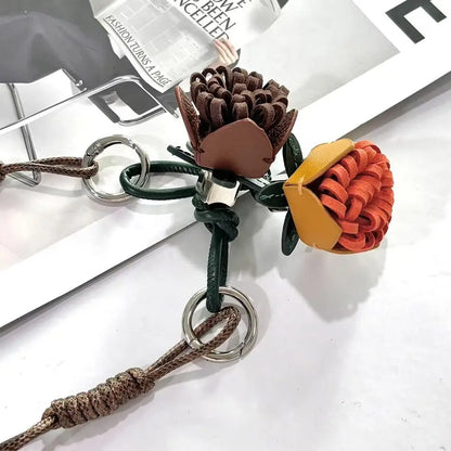 Breloque de sac à main avec pompon fleuri pour femme, porte-clés haut de gamme en cuir PU, pendentif en corde tressée avec pomme de pin et fleur.
